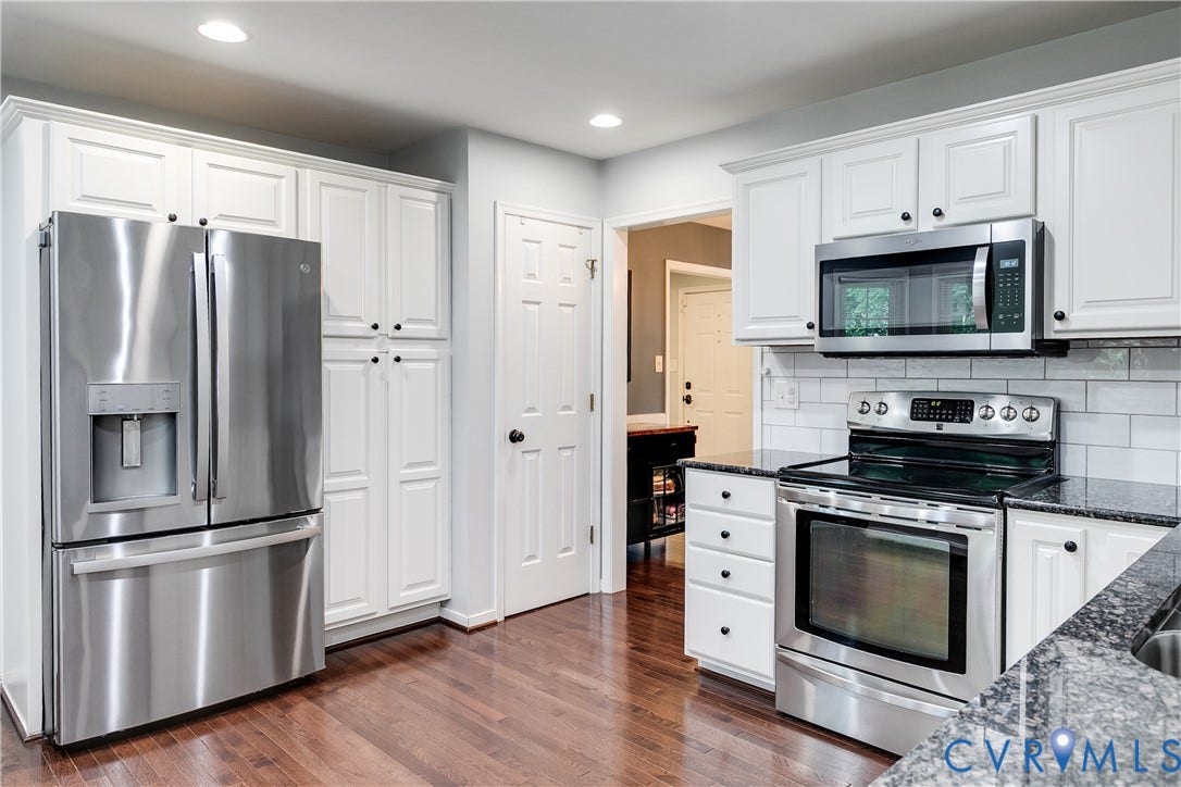 2844 Broadford Lane, Henrico, VA 23233 Stainless steel appliance suite, white shaker-style cabinetry, dark stone countertops, subway tile backsplash, and wood-finish flooring