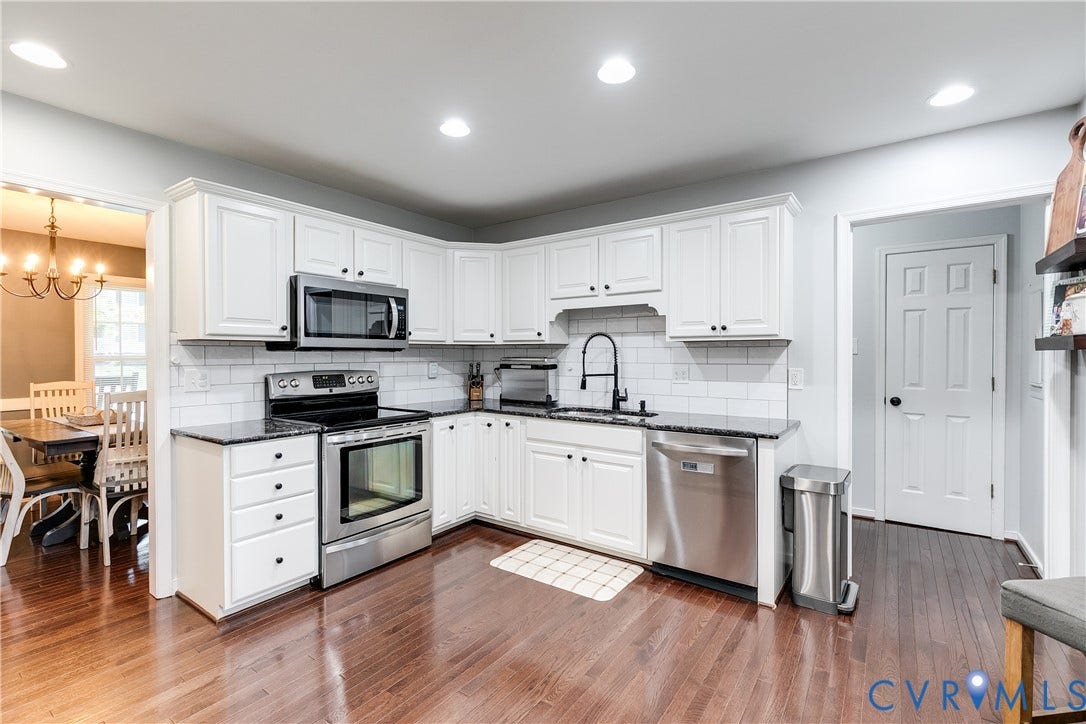 2844 Broadford Lane, Henrico, VA 23233 Kitchen featuring white shaker cabinetry, stainless steel appliances, dark stone countertops, subway tile backsplash, and wood-finish flooring