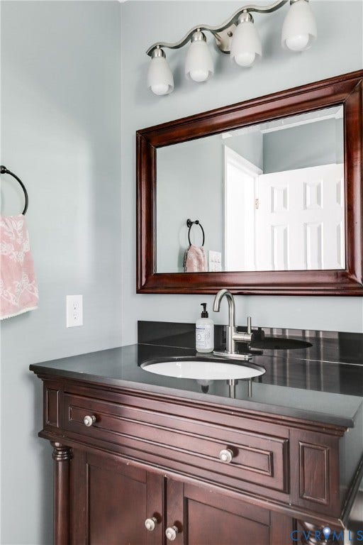 2844 Broadford Lane, Henrico, VA 23233 Dark wood-finish vanity with a built-in sink, dark countertop, and a contemporary faucet