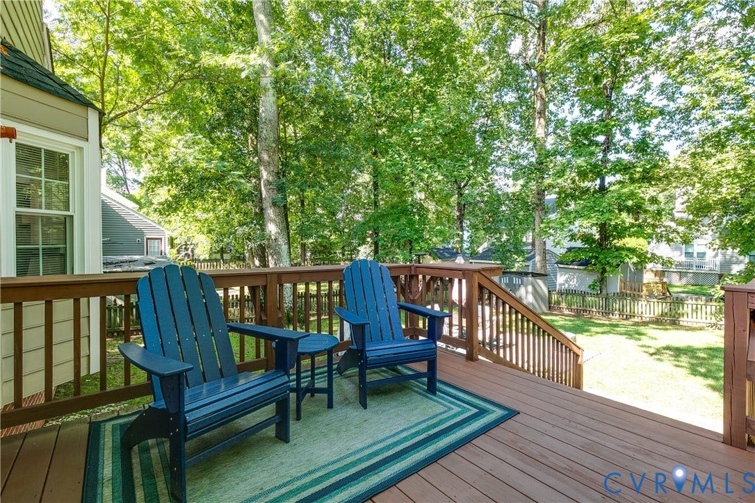 2844 Broadford Lane, Henrico, VA 23233 Expansive wood deck with stairs leading to a fenced backyard featuring a manicured lawn and mature trees