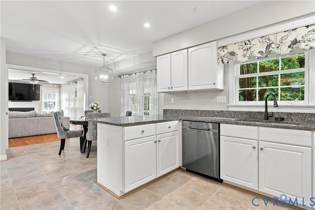 Kitchen featuring white cabinetry, granite countertops, stainless steel dishwasher, and a black gooseneck faucet