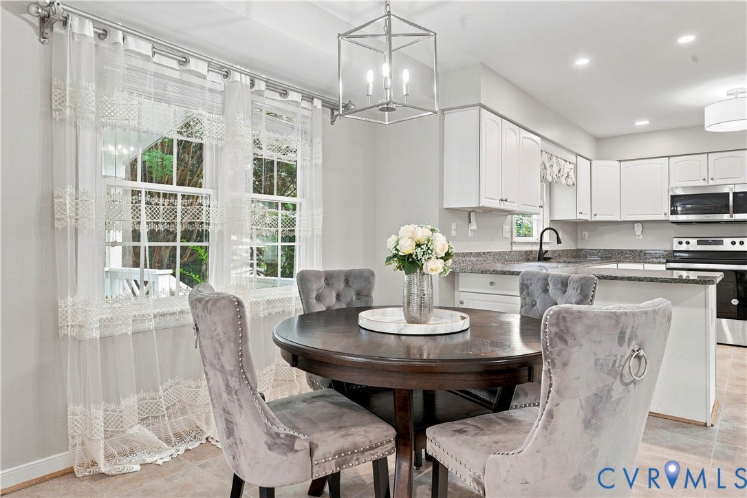 Kitchen featuring white cabinetry, granite-style countertops, stainless steel appliances, and tile flooring