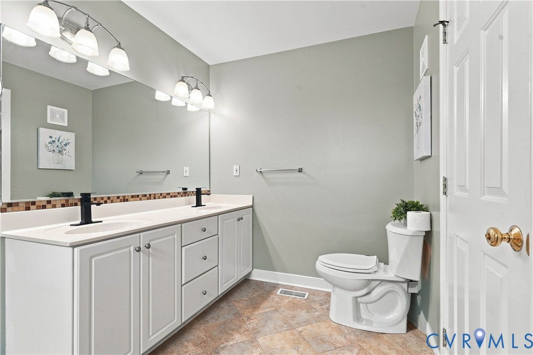 Master Bedroom Bath Dual vanity with white cabinetry, matte black faucets, and a tile backsplash