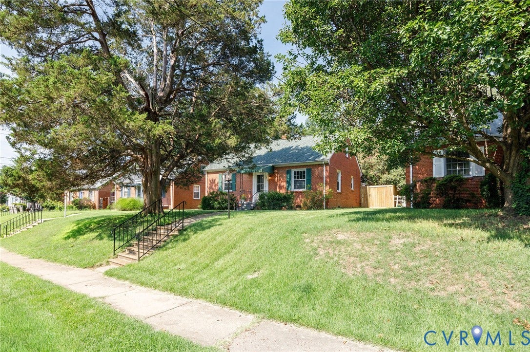 808 W 47th Street, Richmond, VA 23225 Brick exterior with shingled roof, mature trees, and a concrete sidewalk