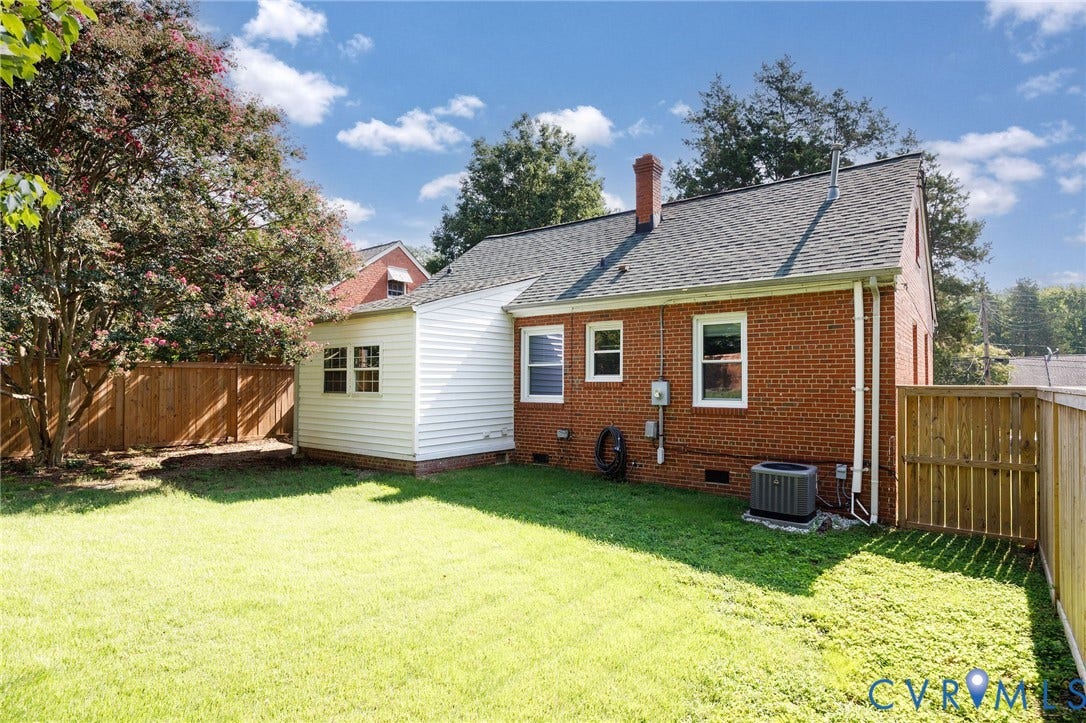 808 W 47th Street, Richmond, VA 23225 Brick exterior with white siding addition, fenced yard, and composition shingle roof