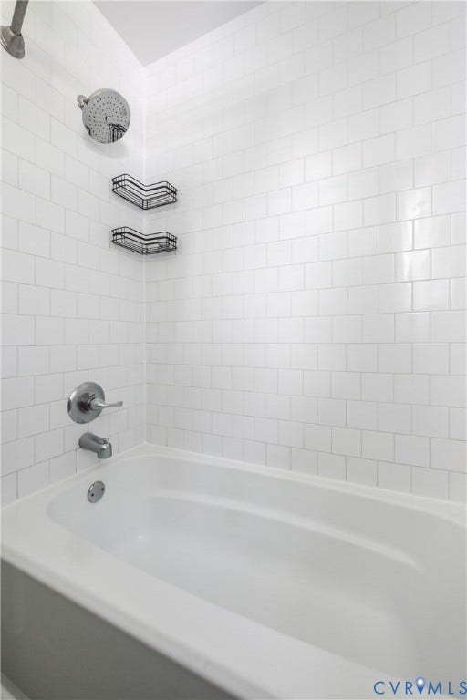 808 W 47th Street, Richmond, VA 23225 Bathtub featuring white subway tile surround, chrome fixtures, and a rain showerhead