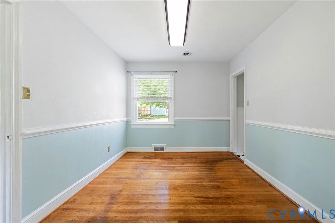 808 W 47th Street, Richmond, VA 23225 Wood-finish flooring with white and light blue walls, featuring a single window with blinds and a fluorescent overhead light fixture