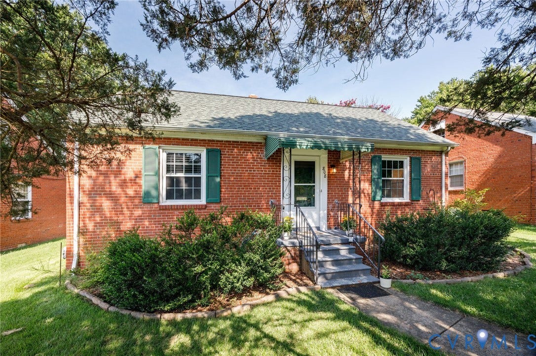808 W 47th Street, Richmond, VA 23225 Red brick exterior with shingled roof, green window shutters, and a front entry with a green awning