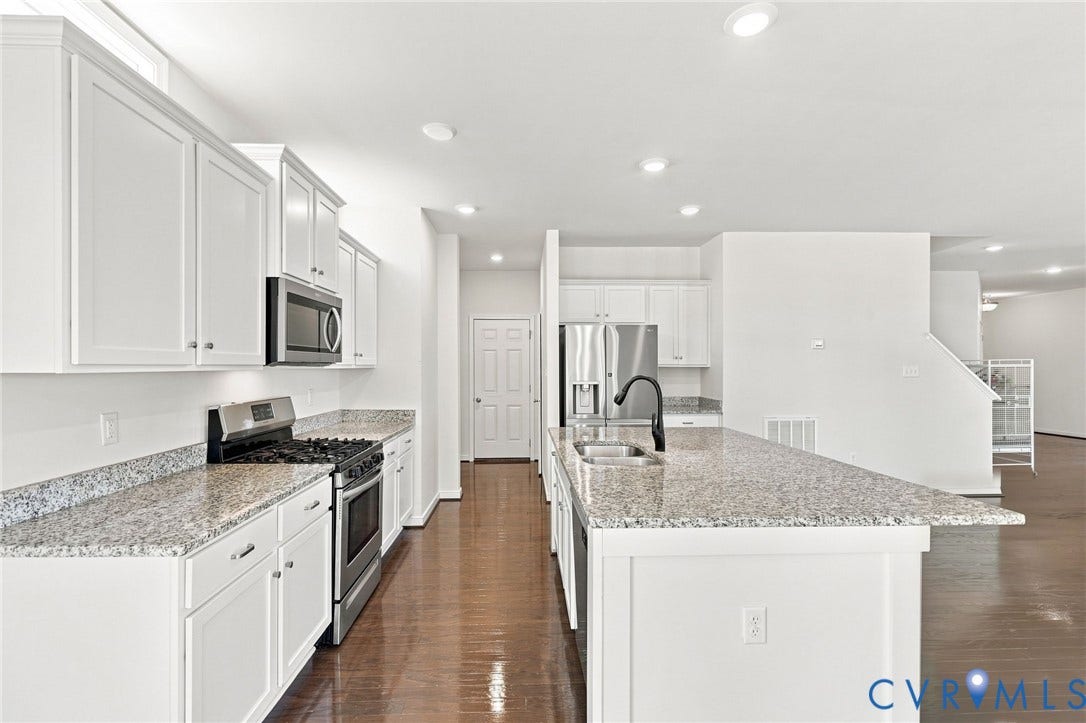 6400 Richwood Trail, Aston Oaks (Section 1), Chesterfield, VA 23120 White shaker cabinetry, stainless steel appliances, granite countertops, center island with sink, and wood-finish flooring