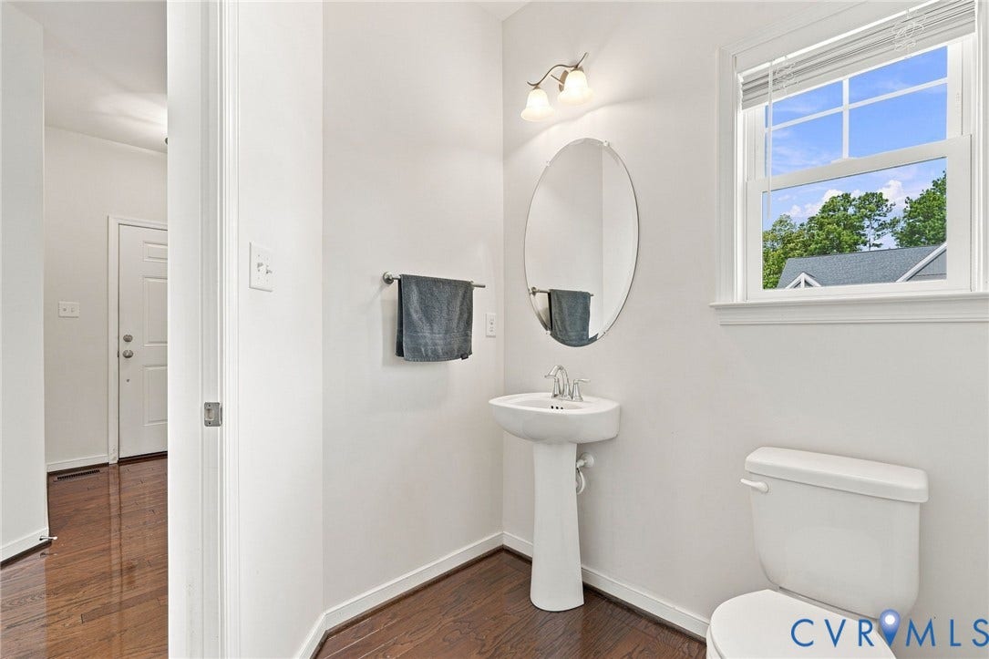 6400 Richwood Trail, Aston Oaks (Section 1), Chesterfield, VA 23120 Pedestal sink with an oval mirror, white-framed window, and wood-finish flooring