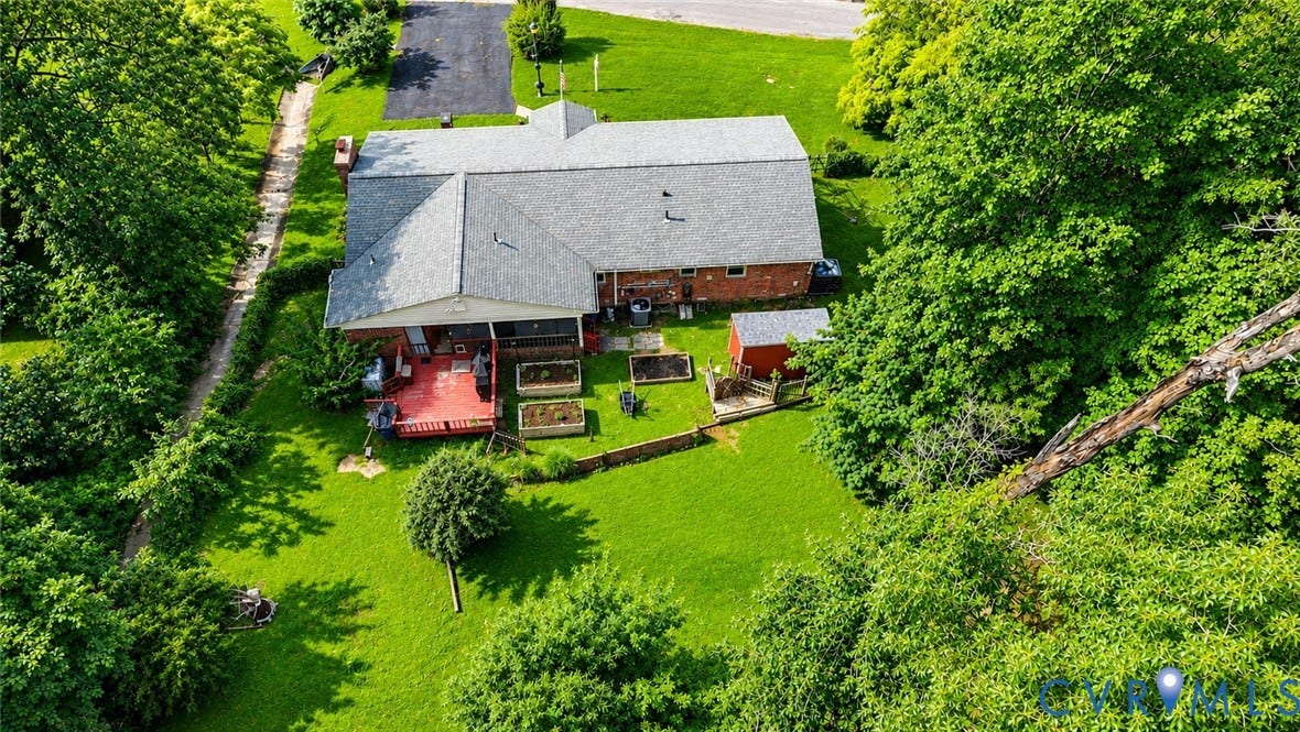 11201 Monday Way, Chesterfield, VA 23112 Expansive green lawn with mature perimeter trees, featuring a red deck, raised garden beds, and a red shed