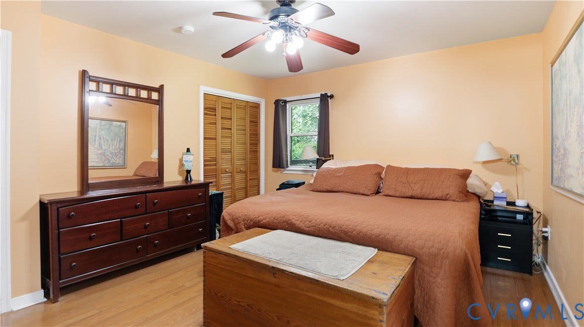 11201 Monday Way, Chesterfield, VA 23112 Spacious primary bedroom featuring warm neutral walls, wood-finish flooring, and abundant natural light from multiple windows
