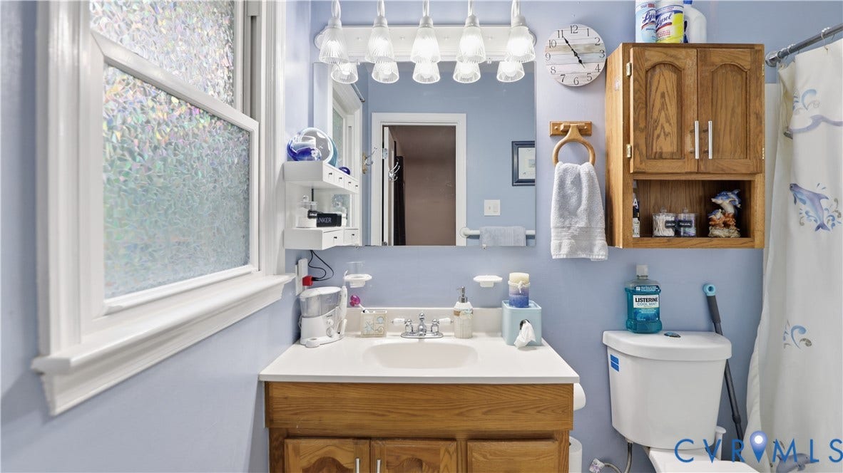 11201 Monday Way, Chesterfield, VA 23112 Oak wood-finish vanity with a white countertop and integrated sink
