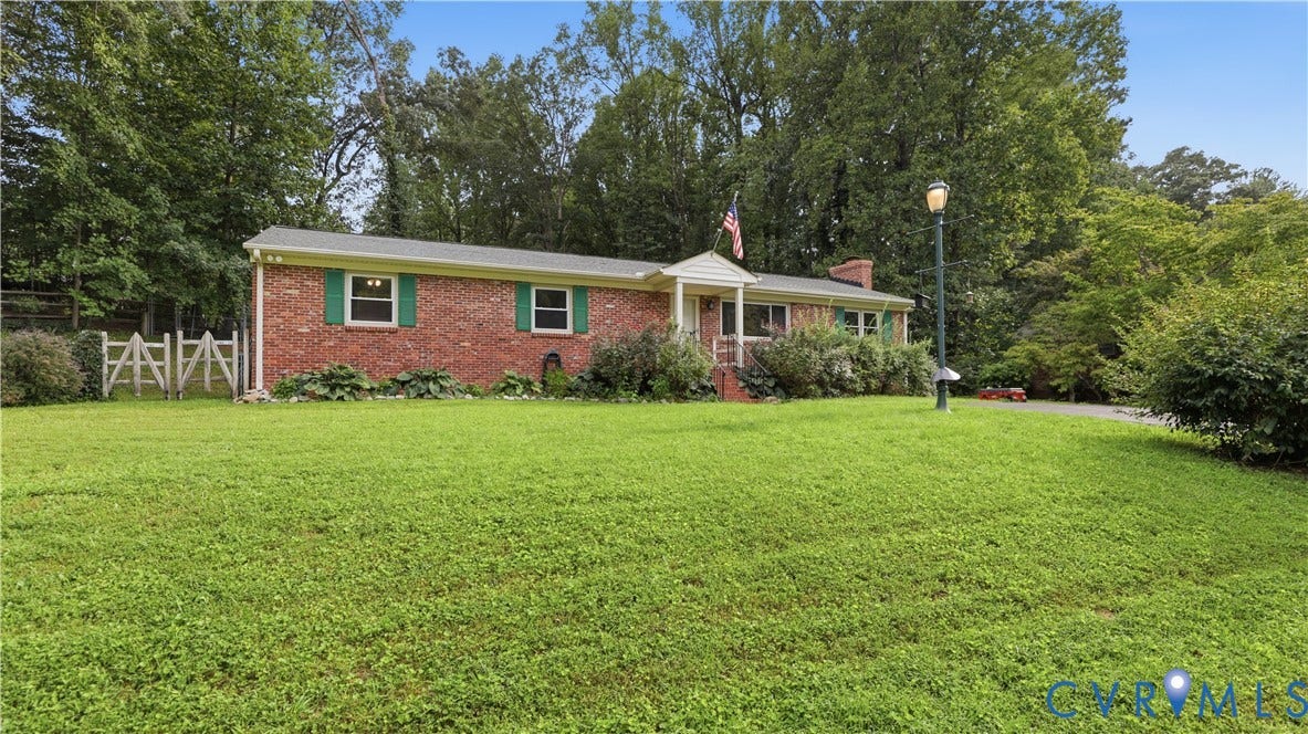 11201 Monday Way, Chesterfield, VA 23112 Brick exterior with green shutters, a welcoming covered porch, and mature trees surrounding the property