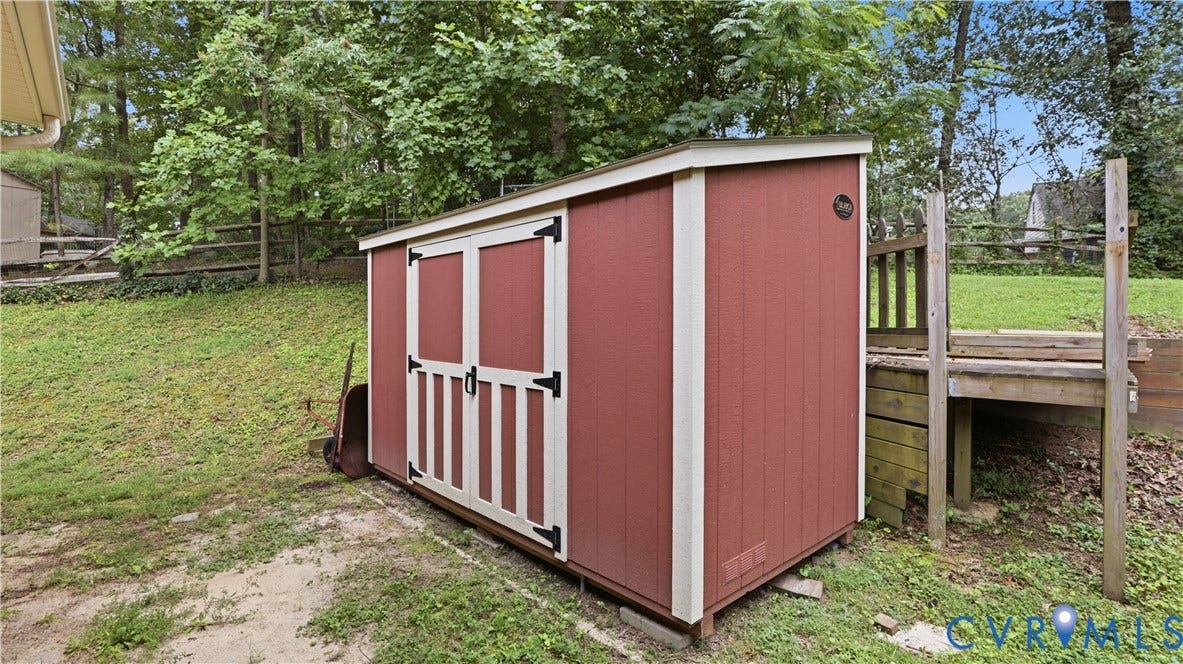 11201 Monday Way, Chesterfield, VA 23112 Red-sided storage shed with white trim and black hardware, positioned on a gravel and grass surface