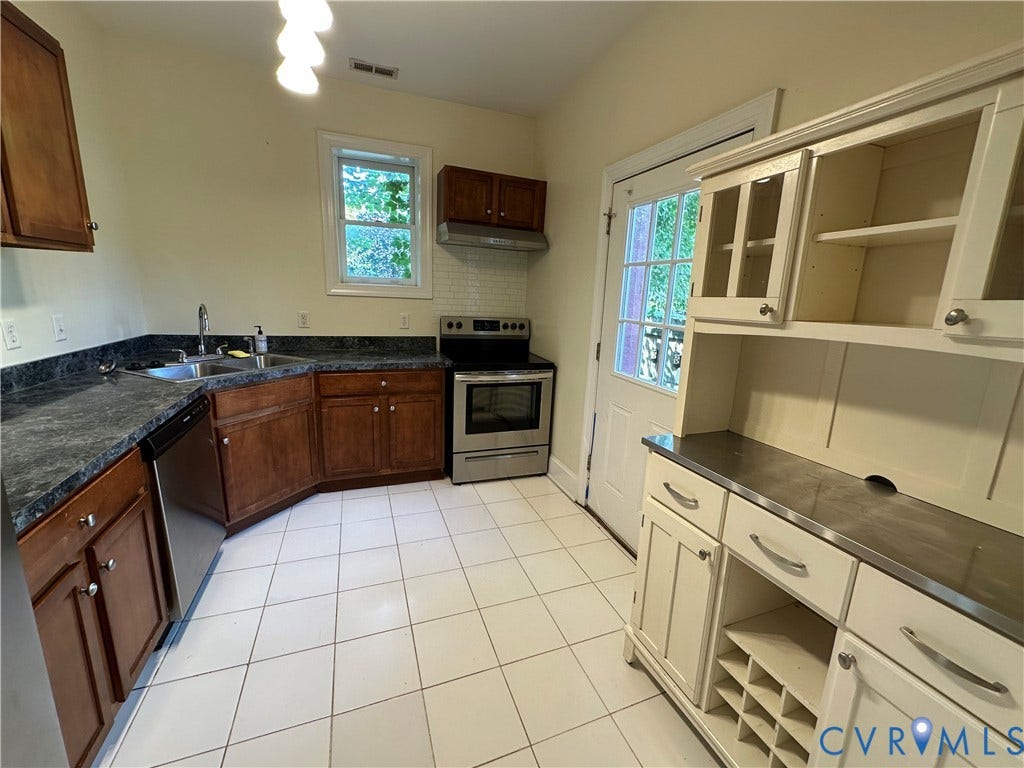 522.5 N 1st Street, Richmond, VA 23219 Kitchen featuring dark wood-finish cabinetry, stainless steel appliances, dark countertops, white tile flooring, and a built-in hutch