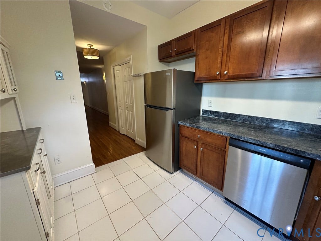 522.5 N 1st Street, Richmond, VA 23219 Kitchen with white tile flooring, stainless steel appliances, dark wood-finish cabinetry, and a dark patterned countertop