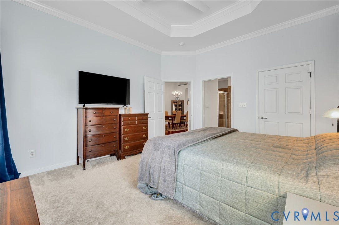 2811 Murano Way, The Villas At Hunton Park, Glen Allen, VA 23059 Spacious primary bedroom featuring a tray ceiling with recessed lighting, carpet flooring, and an entertainment dresser with flat-screen television mount