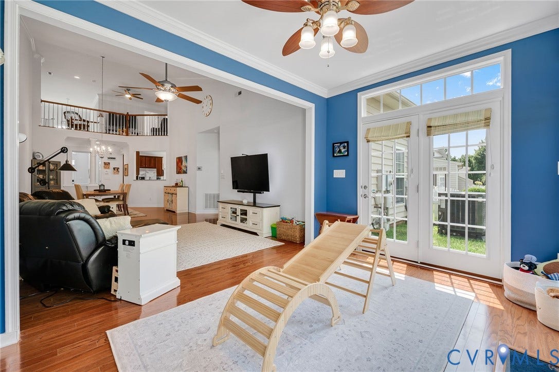 2811 Murano Way, The Villas At Hunton Park, Glen Allen, VA 23059 Bright open-concept living space featuring hardwood flooring, bold blue accent walls, and abundant natural light from French doors and transom windows
