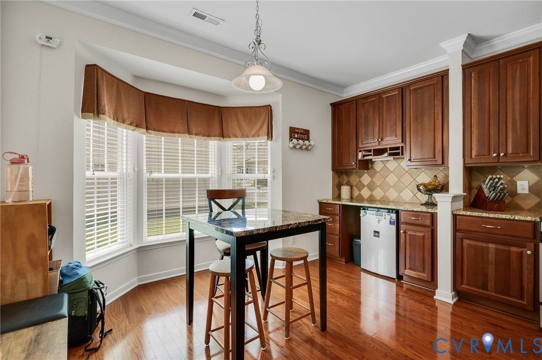 2811 Murano Way, The Villas At Hunton Park, Glen Allen, VA 23059 Rich wood-finish flooring with a bay window, crown molding, and built-in cabinetry featuring a tile backsplash