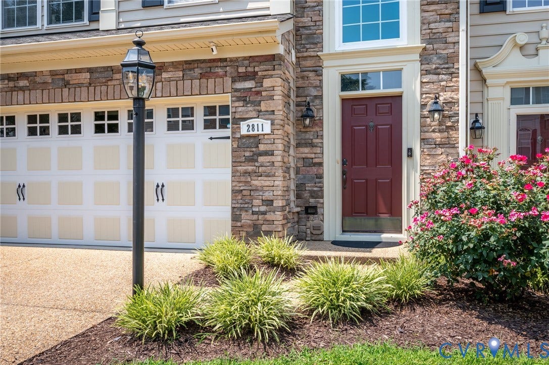 2811 Murano Way, The Villas At Hunton Park, Glen Allen, VA 23059 Stone veneer facade with a paneled garage door, a prominent front door, and established landscaping