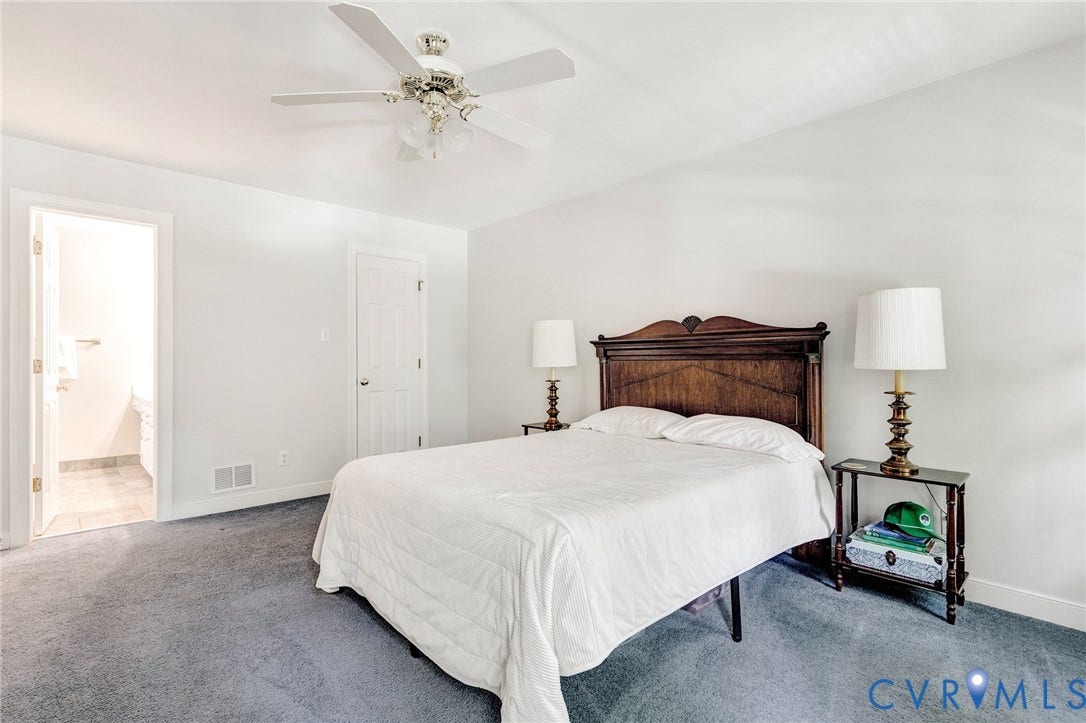 16406 Inchcape Road, Chesterfield, VA 23120 Spacious primary bedroom featuring a wood-finish headboard, ceiling fan with integrated lighting, neutral wall finishes, and carpeted flooring