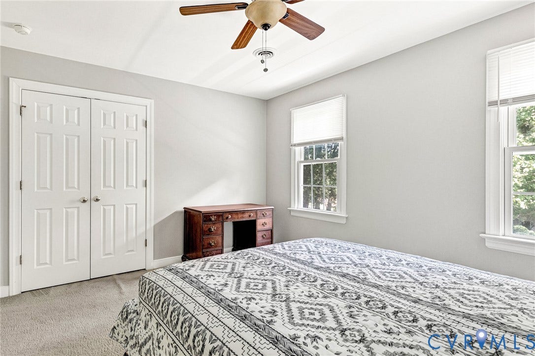 16406 Inchcape Road, Chesterfield, VA 23120 Carpeted flooring, white six-panel bifold doors, window with white blinds, white trim, and a ceiling fan with light fixture