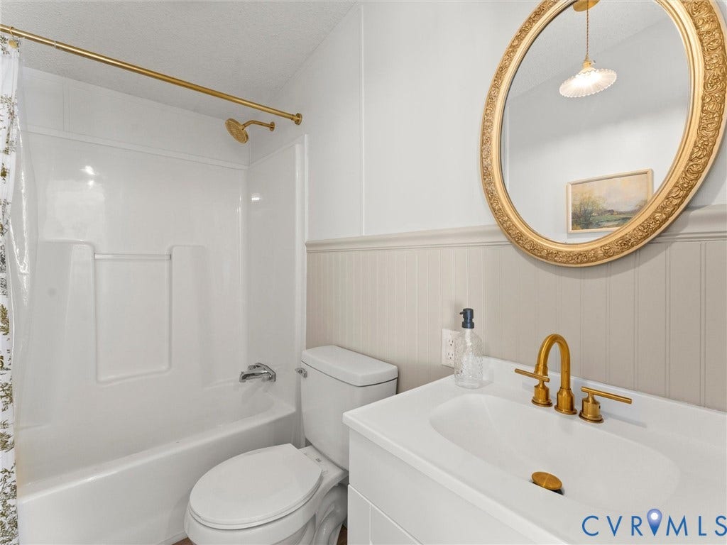 4554 Powhatan Lakes Road, Powhatan, VA 23139 White vanity with integrated sink, gold-tone faucet, and decorative oval mirror