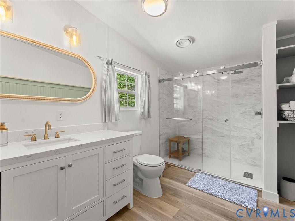 4554 Powhatan Lakes Road, Powhatan, VA 23139 White vanity with a quartz countertop, gold-finish faucet, and an oval mirror