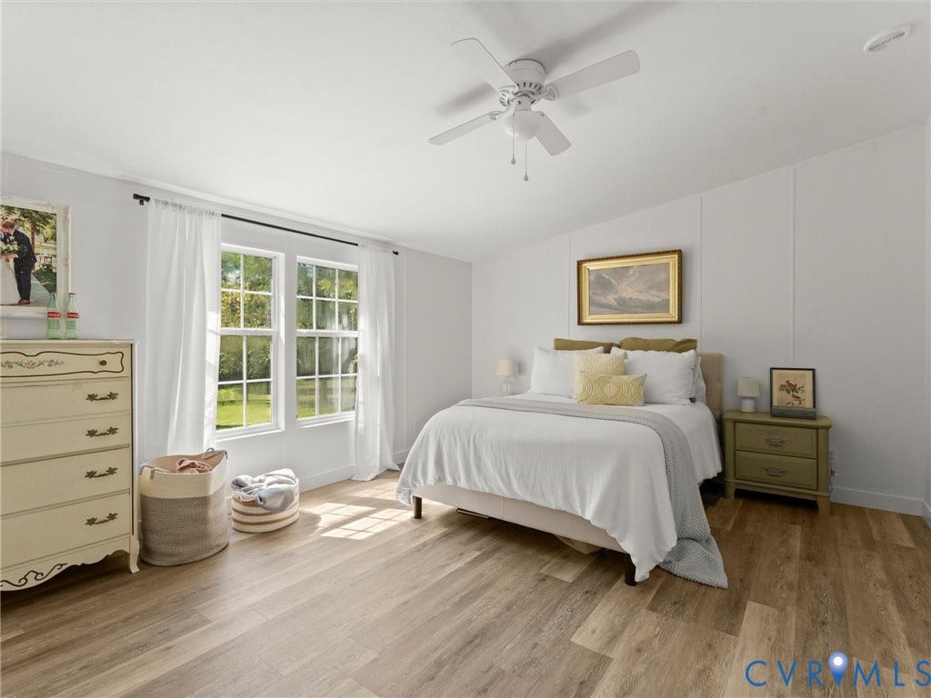 4554 Powhatan Lakes Road, Powhatan, VA 23139 Bright secondary bedroom featuring wood-finish flooring, a ceiling fan with pull-chain controls, and large multi-pane French doors with white curtain panels