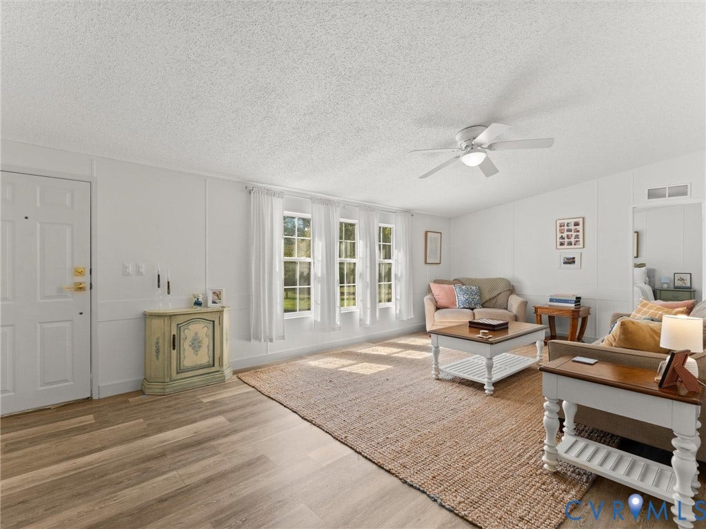 4554 Powhatan Lakes Road, Powhatan, VA 23139 Spacious room featuring wood-finish flooring, multiple windows, a ceiling fan, and a white paneled door