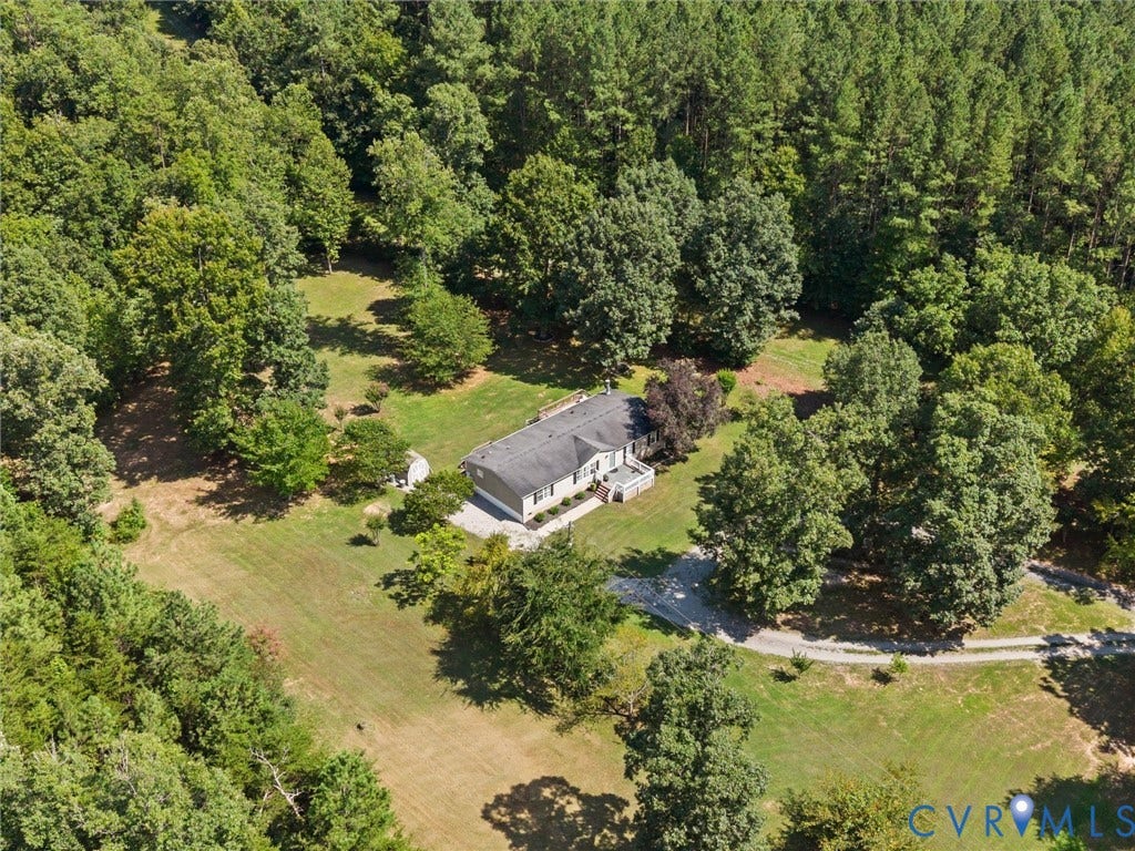 4554 Powhatan Lakes Road, Powhatan, VA 23139 Expansive property featuring a single-story residence, a gravel driveway, mature trees, and open green spaces