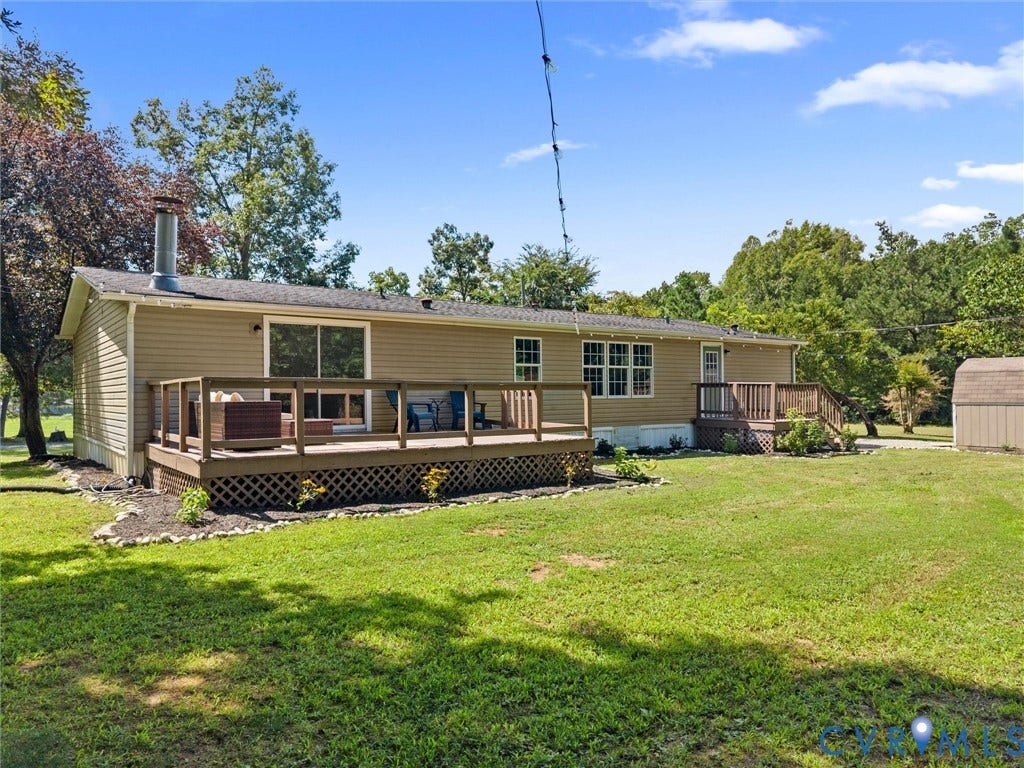 4554 Powhatan Lakes Road, Powhatan, VA 23139 Charming manufactured home featuring a spacious covered front porch with lattice foundation skirting, vinyl siding exterior, and multiple windows allowing natural light throughout