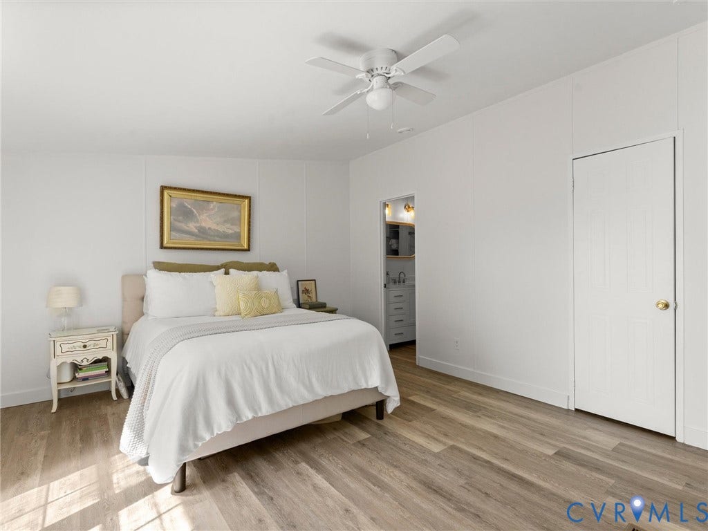 4554 Powhatan Lakes Road, Powhatan, VA 23139 Wood-finish flooring, white paneling, ceiling fan with light fixture, and a solid white door