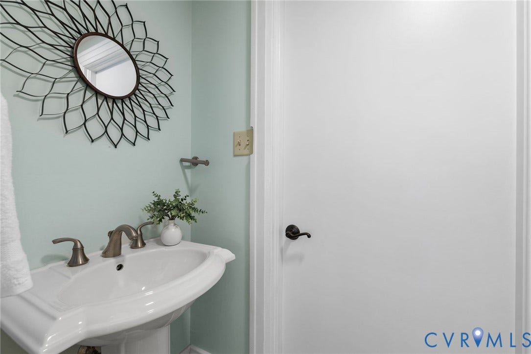 HALF BATH - Pedestal sink with a two-handle faucet and light-toned walls