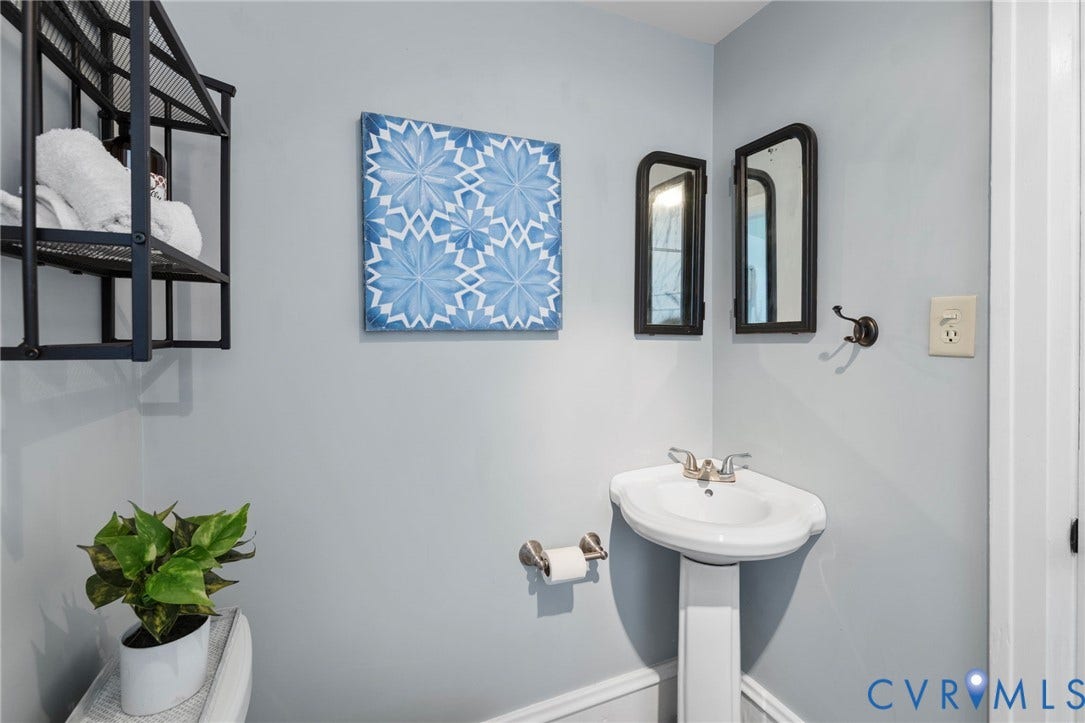 Pedestal sink, wall-mounted faucet, and two framed mirrors