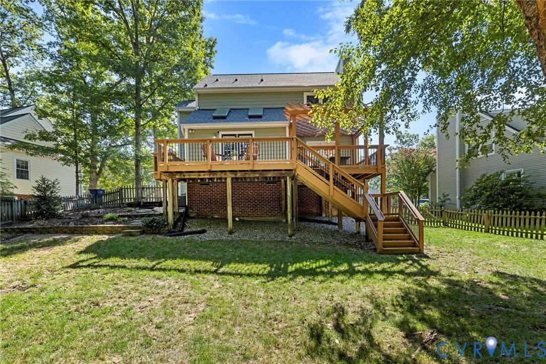 2308 Strangford Court, Henrico, VA 23233 Multi-level wood deck with stairs leading to a spacious lawn, featuring a brick foundation and partial privacy fencing