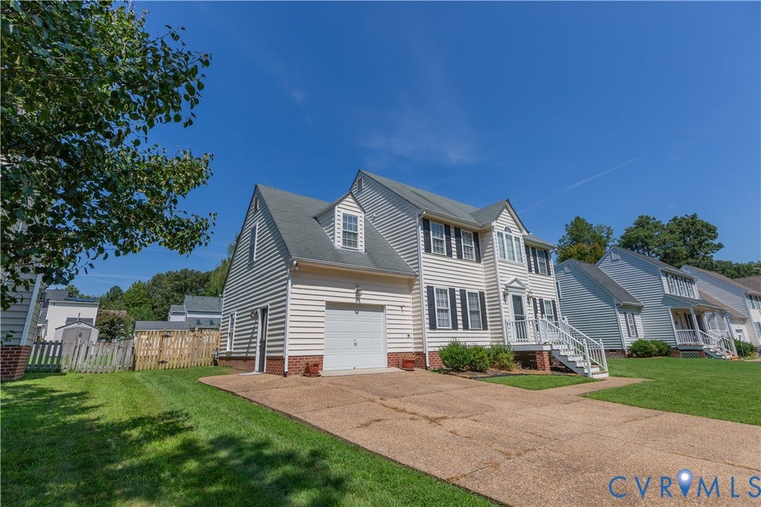 Two-story residence with white siding, attached garage, and a concrete driveway