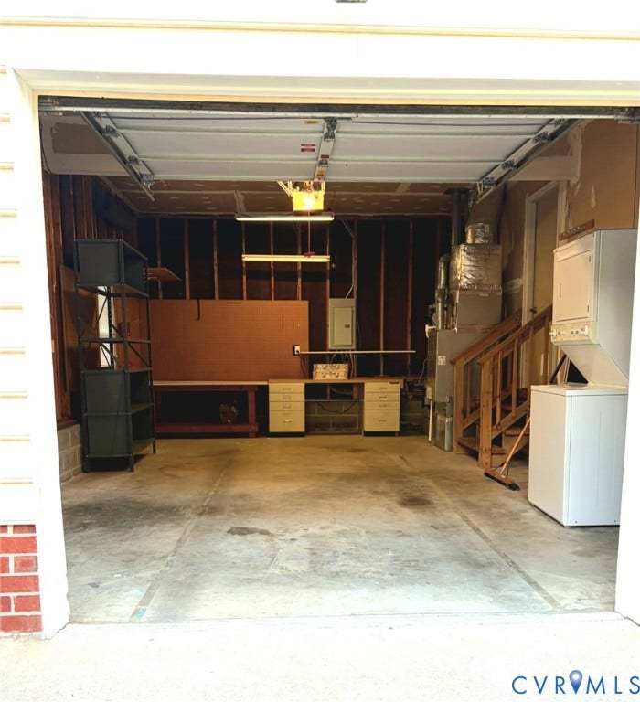 Concrete flooring with built-in cabinetry, an integrated workbench, and overhead lighting