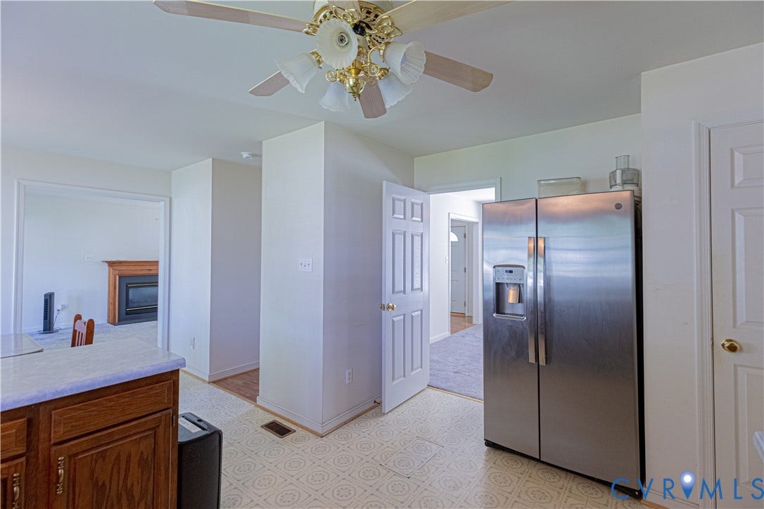 Kitchen featuring a ceiling fan with light fixture, wood cabinetry, and a side-by-side stainless steel refrigerator