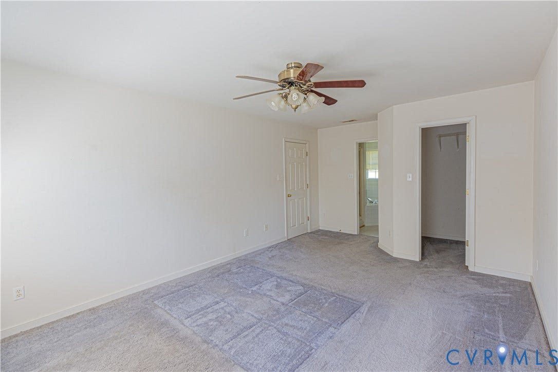 Carpeted room featuring a ceiling fan with integrated lighting, a white painted door, and an open closet