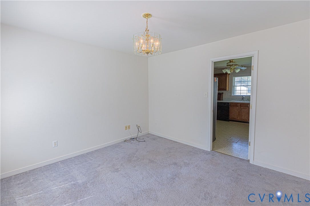 Light gray carpeting and a gold-finish chandelier illuminate the room