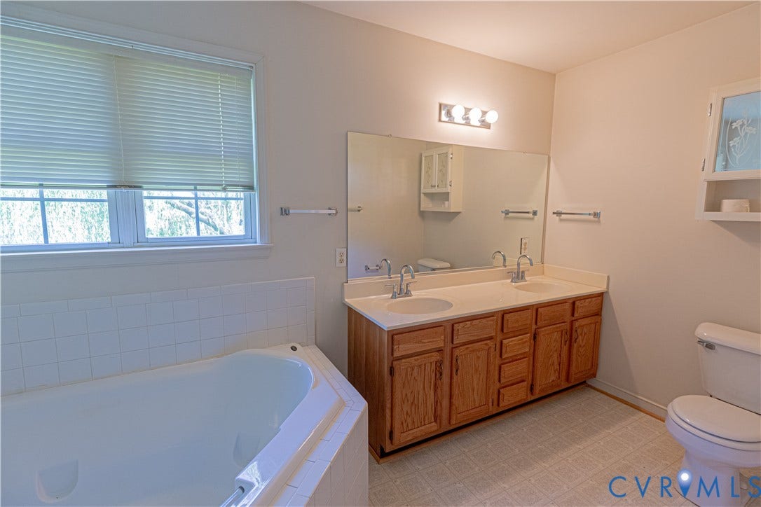 Dual vanity with integrated sinks, large wall mirror, and overhead lighting