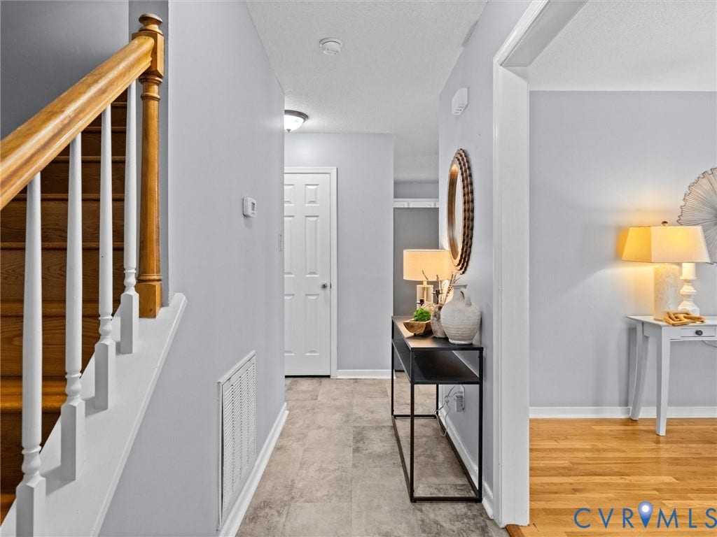6712 N Hedges Road, Chesterfield, VA 23224 Entryway featuring a wood staircase with white balusters, light gray walls, and gray wood-finish flooring