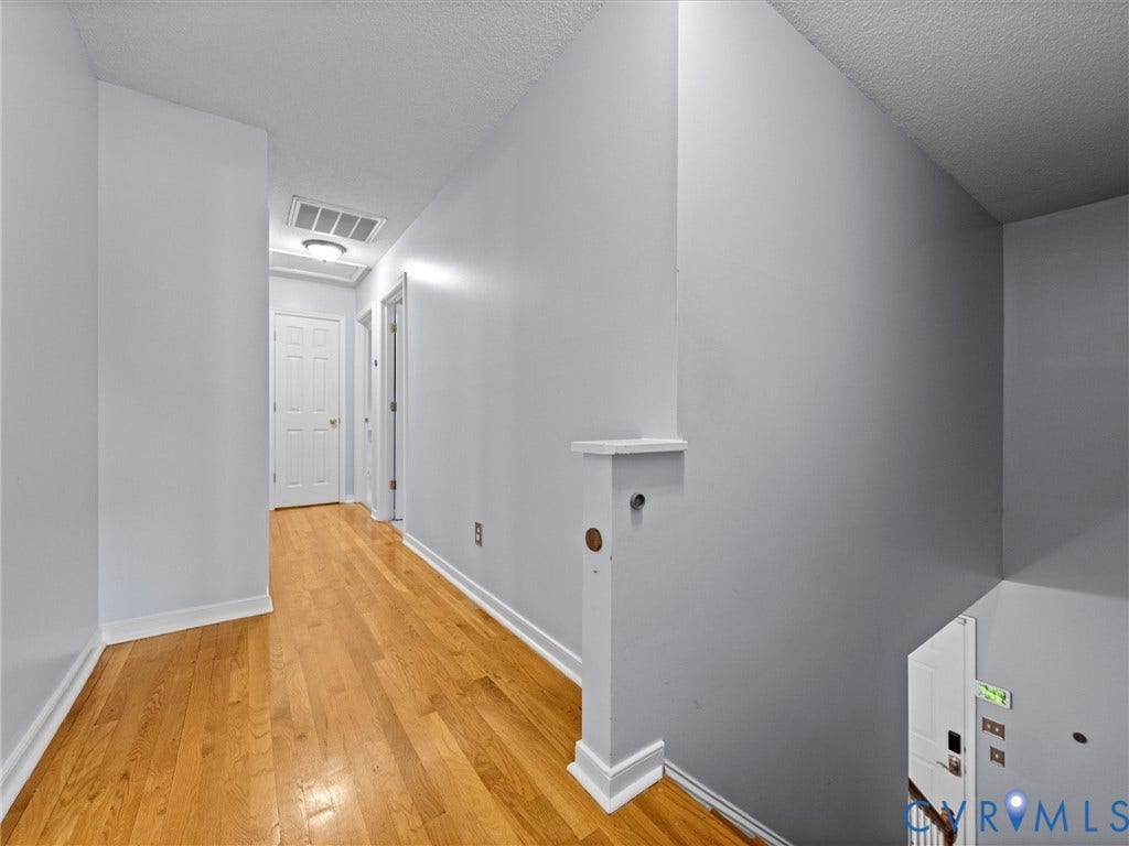 6712 N Hedges Road, Chesterfield, VA 23224 Hallway featuring wood-finish flooring, light gray walls, and white trim