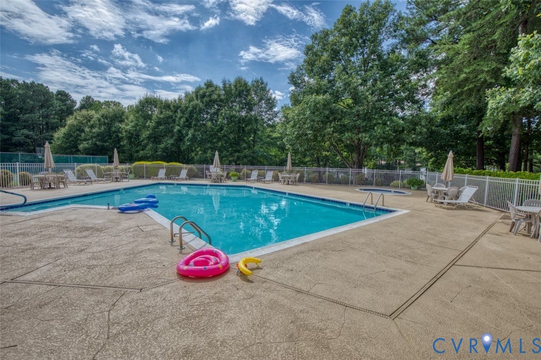 6311 Chiswick Park, Williamsburg, VA 23188 Resort-style in-ground swimming pool with crystal-clear water, surrounded by expansive concrete decking and white vinyl fencing