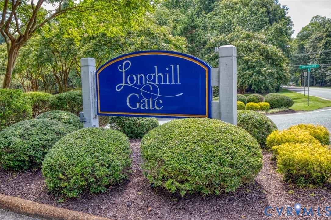 6311 Chiswick Park, Williamsburg, VA 23188 Longhill Gate Community Entrance featuring an elegant blue and silver monument sign with refined landscaping, including manicured boxwood hedges and mature shade trees framing the gated community access