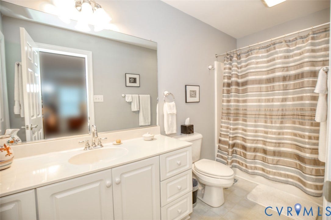 6311 Chiswick Park, Williamsburg, VA 23188 Spa-inspired bathroom featuring a generous vanity with dual sink basins, abundant storage cabinetry, and quartz countertop