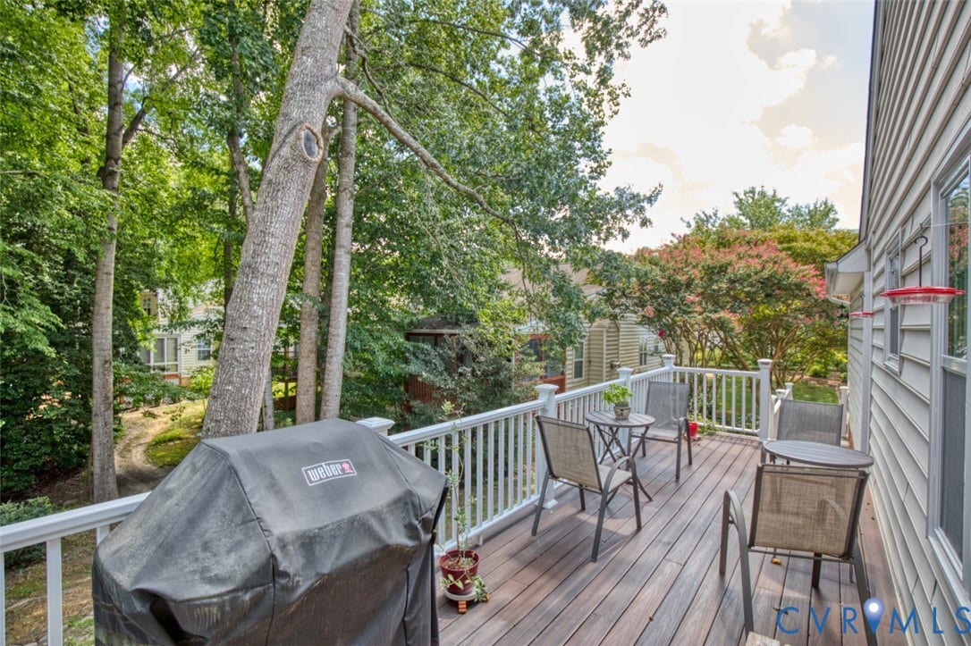 6311 Chiswick Park, Williamsburg, VA 23188 Composite deck with composite decking and white aluminum railings overlooking mature landscaping