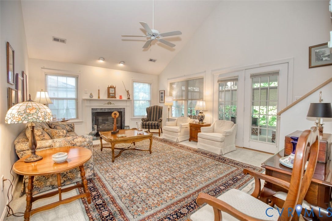 6311 Chiswick Park, Williamsburg, VA 23188 Vaulted ceiling with a ceiling fan, fireplace with a mantel, multiple windows, and exterior access via double glass-paneled doors